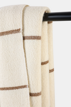 Woven Nubra Dunes Wool Throw in natural white wool with walnut-dyed stripe detailing and fringed edges