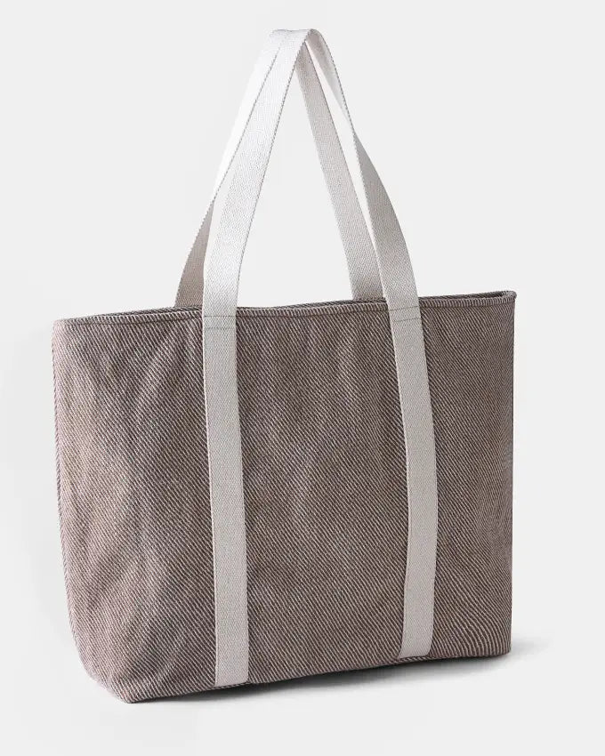 Ri Travel Bag showcasing natural undyed and walnut husk–dyed wool weave